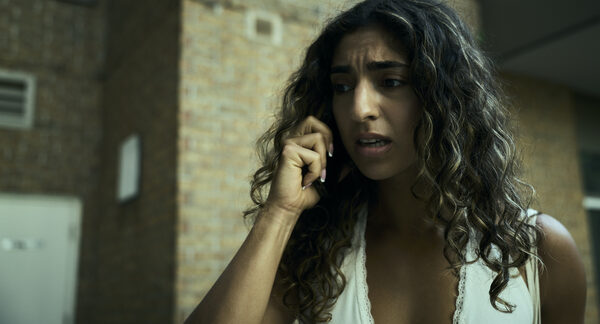 The Actor on a phone call outside a brick building, mid-argument.