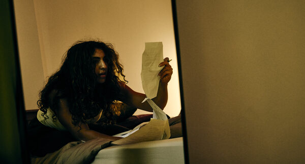 The Actor reading a page by lamplight, reflected in a mirror.